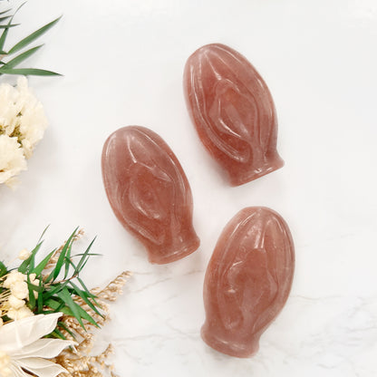 Triple the Power of Love and Empowerment: A captivating display of three Strawberry Quartz crystal vulva shapes, each representing the sacred source of life and symbolizing the strength and beauty of femininity. The soft pink hues of these gemstones evoke love, compassion, and emotional healing.