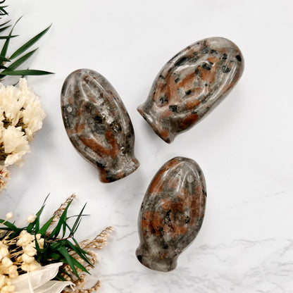 Glowing with Feminine Power: A captivating trio of Yooperlite crystal vulva shapes, each radiating with a mystical, ethereal glow under UV light. Yooperlite symbolizes the divine feminine and the vitality of female strength.