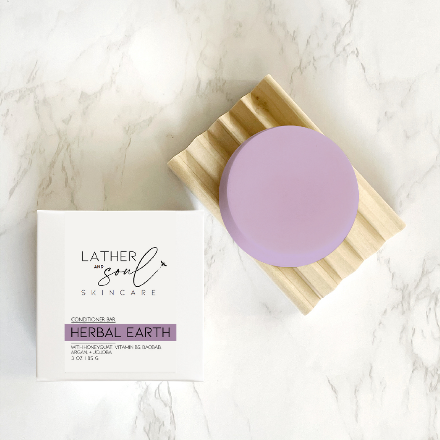 Eco friendly solid conditioner bar from Lather and Soul on wooden dish on marble table.