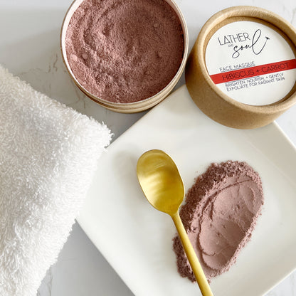 Lather & Soul hibiscus and carrot face masque with a gold spoon on a white plate