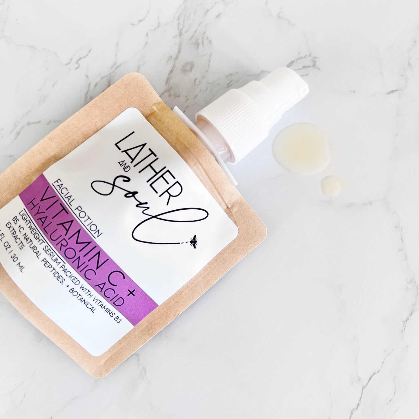 Facial potion with vitamin C and hyaluronic acid on a marble surface