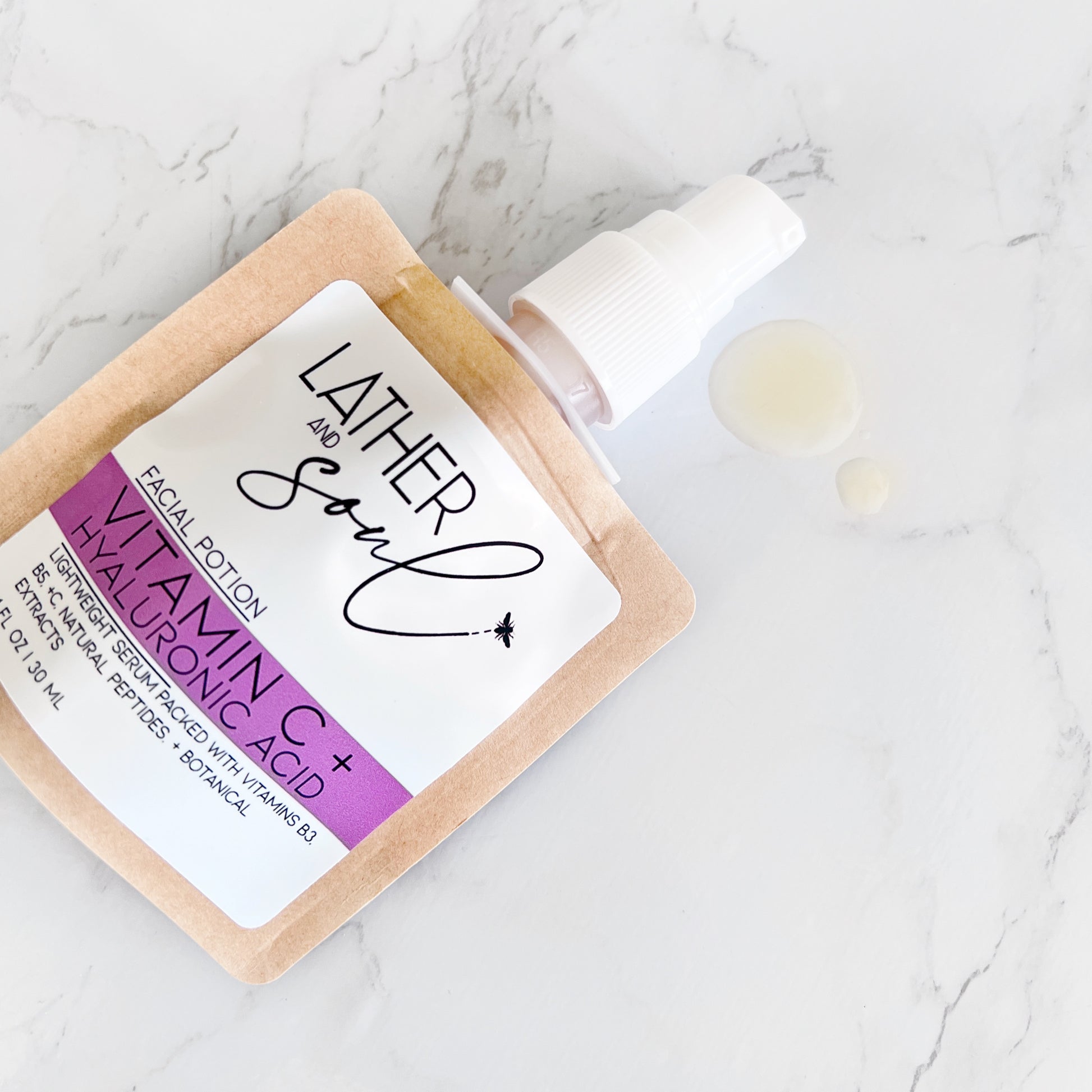 Facial potion with vitamin C and hyaluronic acid on a marble surface