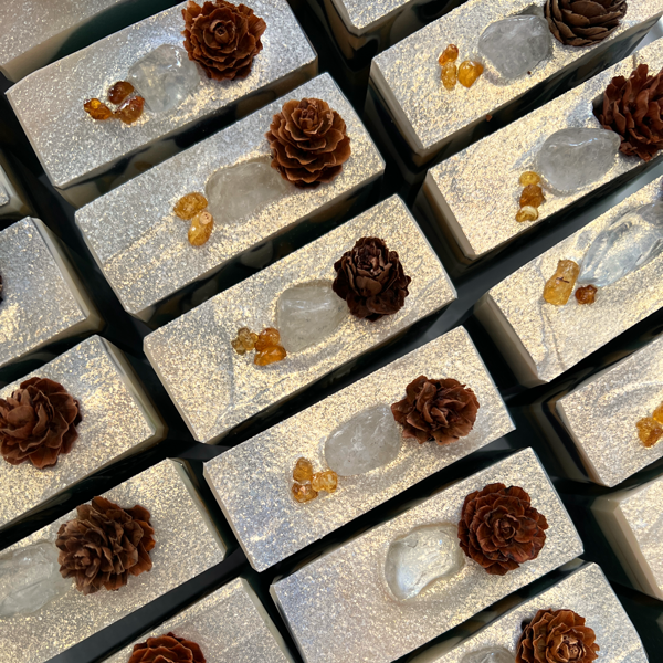 Close up of Lather + Soul's Yule Crystal soap, with clear quartz, frankincense, and mini pinecone 