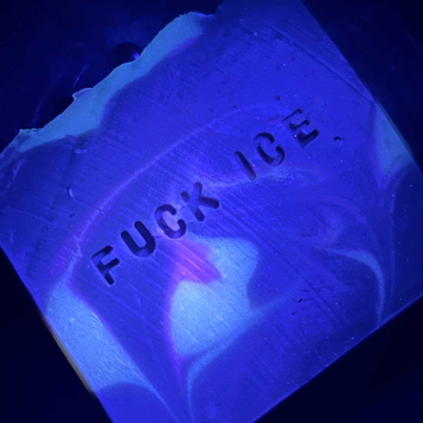 Glow in the dark soaps under UV light that have "F*c ICE" stamped into each bar