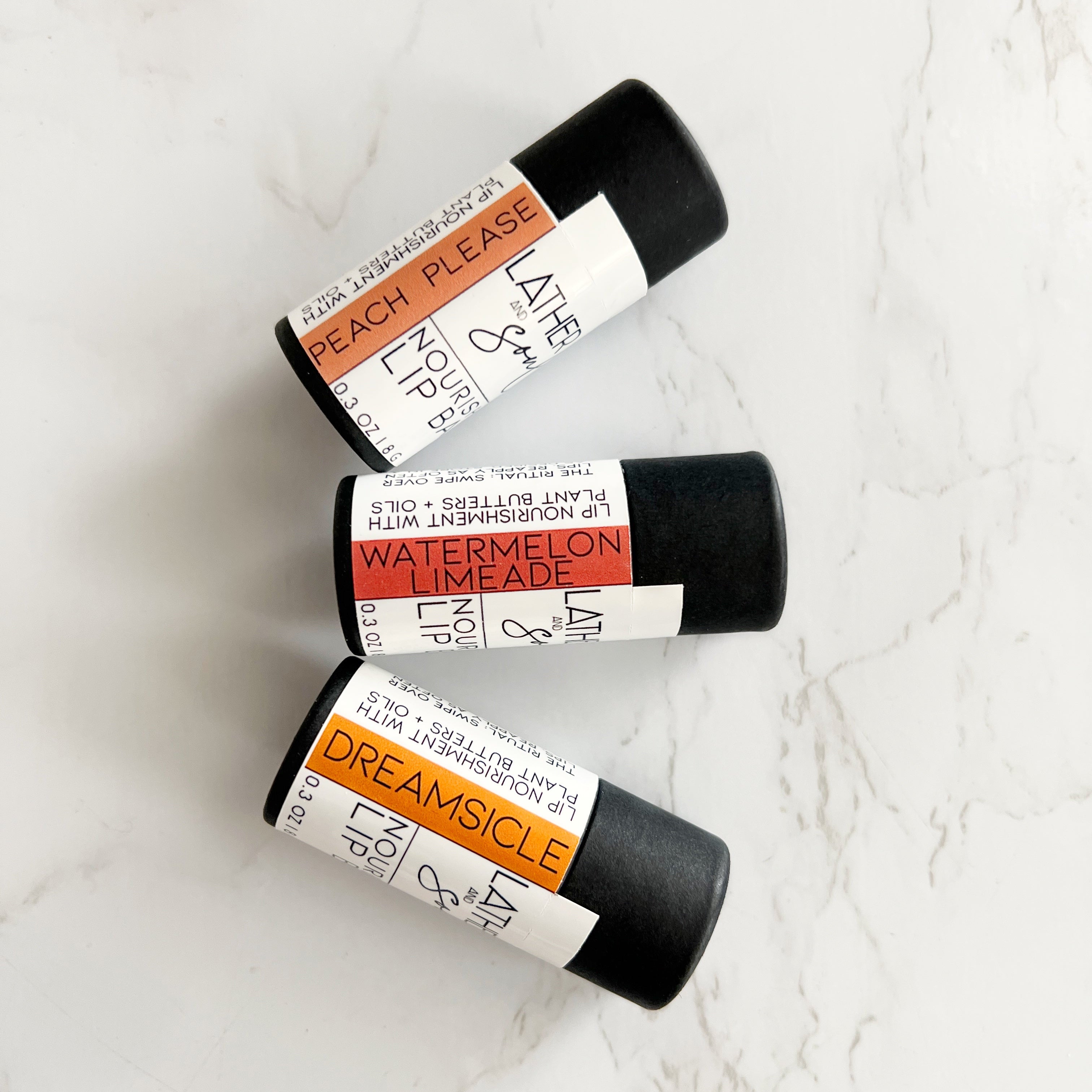 Summer inspired lip balms from Lather and Soul, in eco friendly paperboard tubes; Peach Please, Watermelon Limeade, and Dreamsicle