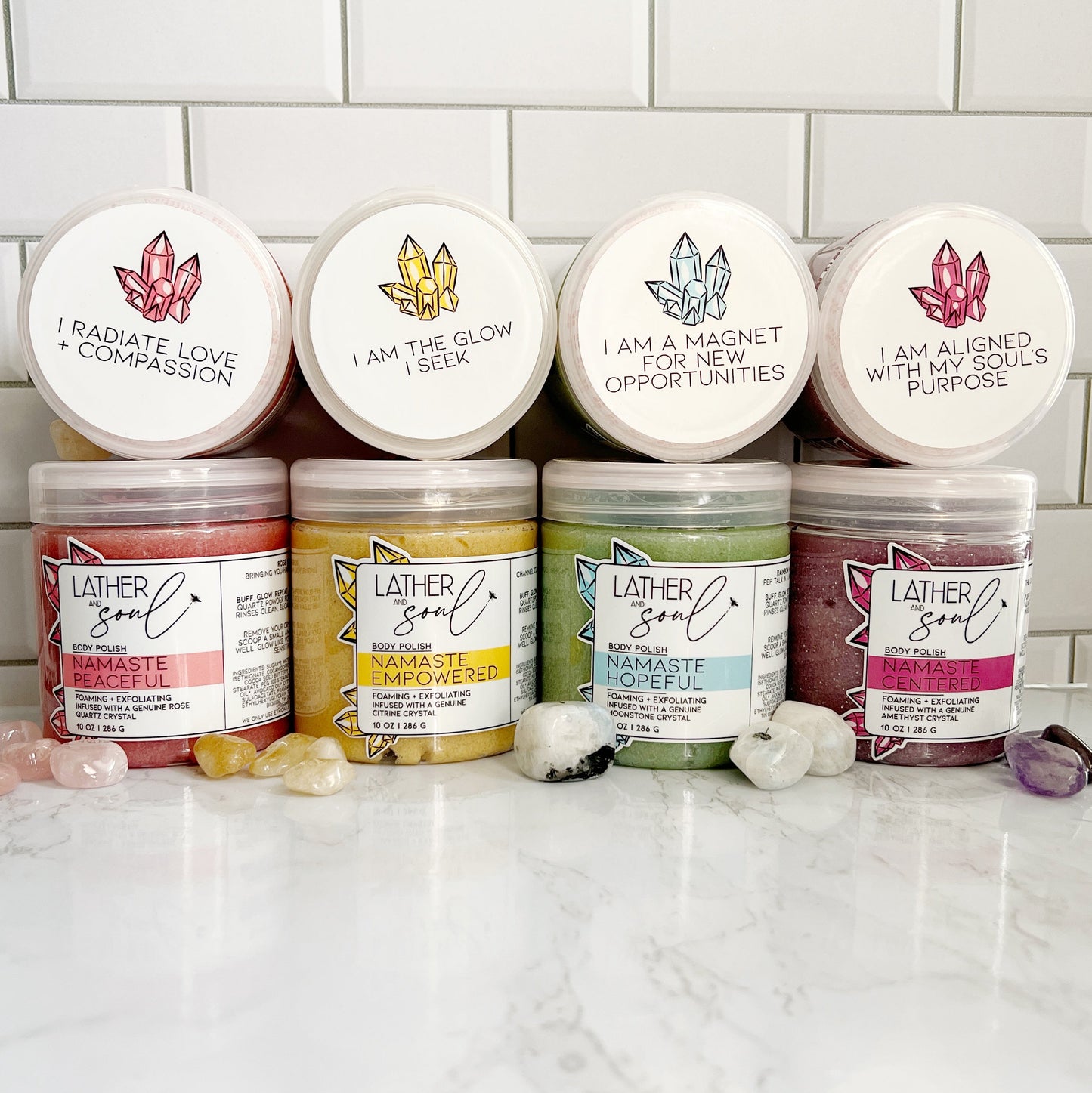 Collection of Lather & Soul Boyd scubs on a white countertop with a tiled wall background.