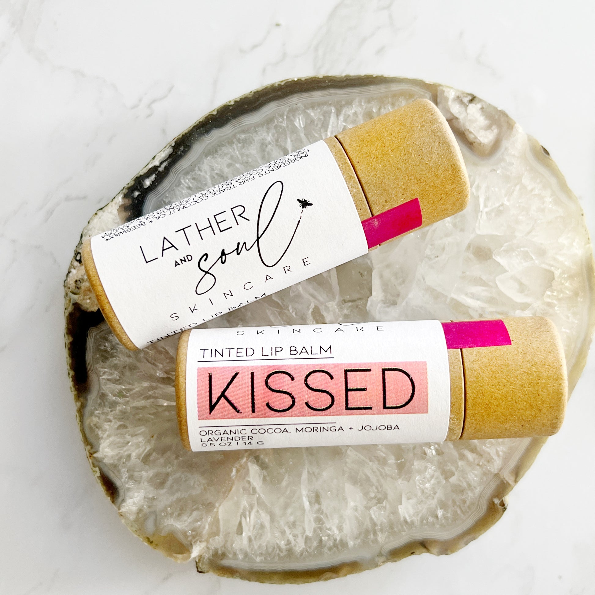 "Kissed," rose gold organic tinted lip balm in paperboard tube.
