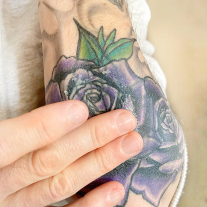 Applying tattoo aftercare salve to tattoo